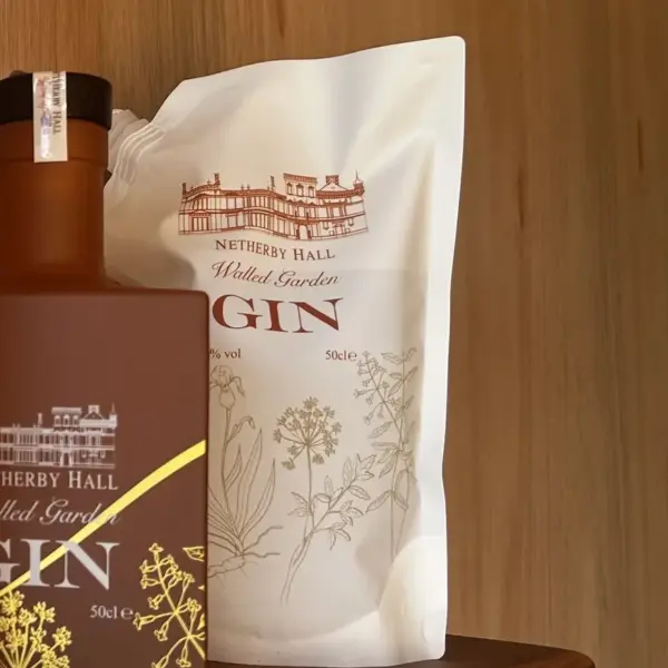 Close-up of Netherby Hall Walled Garden Gin bottle and botanical-themed 50cl refill pouch