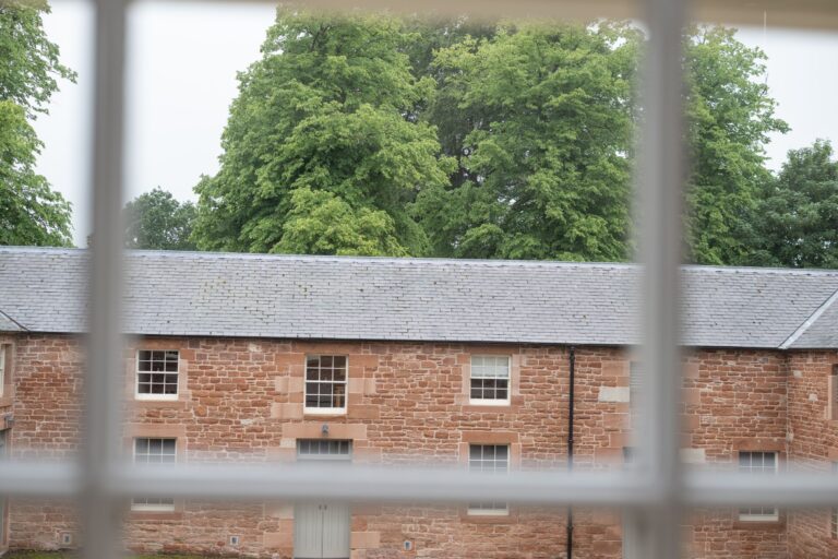 Exterior view of the red sandstone Clock Tower Apartment at Netherby Hall, luxury self-catering accommodation in Cumbria