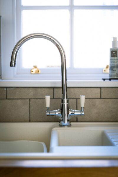 Modern chrome kitchen tap and sink in the Coach House luxury self-catering apartment at Netherby Hall, Cumbria