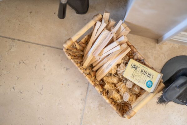 Woven basket with kindling wood and Cook's Matches for the fireplace in the Coach House luxury self-catering apartment at Netherby Hall, Cumbria