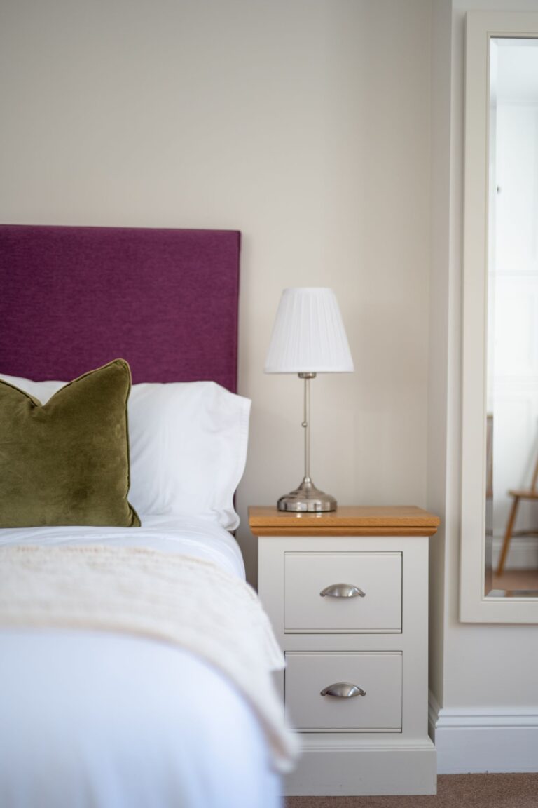 Bedroom interior at Coach House luxury self-catering accommodation in Cumbria featuring a white bedside table and lamp