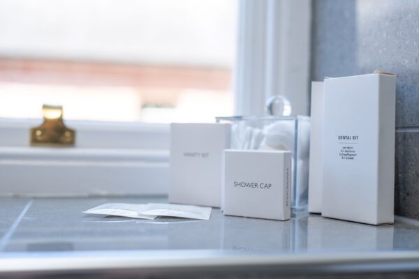 Luxury toiletries and amenities including a dental kit and shower cap in the Coach House apartment at Netherby Hall, Cumbria