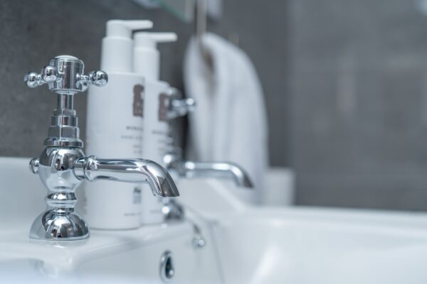 Chrome faucet and toiletries in the luxury bathroom of the Coach House apartment at Netherby Hall