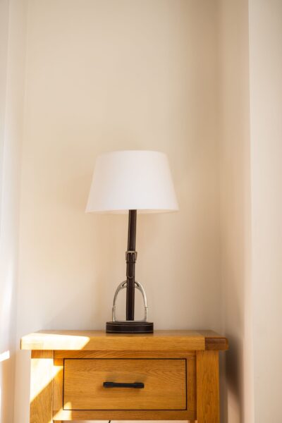 Elegant table lamp on a wooden bedside chest in the Coach House luxury self-catering apartment at Netherby Hall, Cumbria