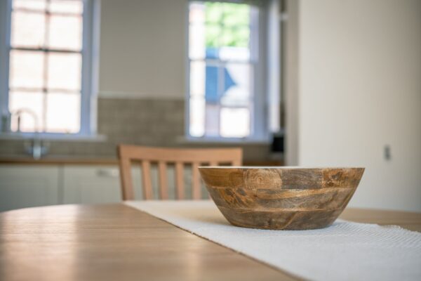 Wooden bowl on a dining table in the Coach House luxury self-catering apartment at Netherby Hall, Cumbria