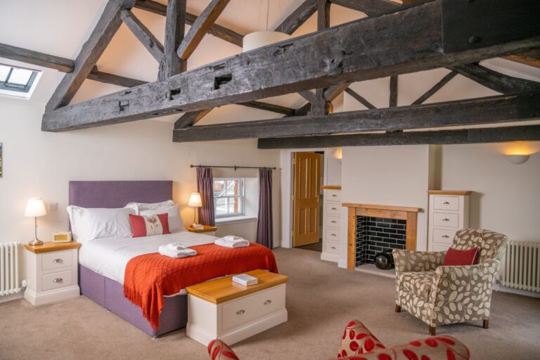 Bedroom in the Engineer Apartment at Netherby Hall, featuring rustic exposed ceiling beams and luxury furnishings