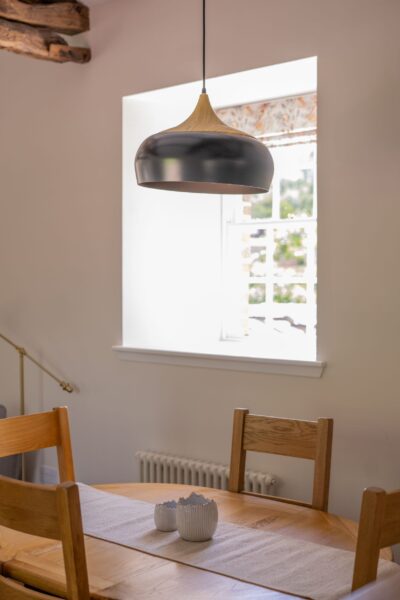 Dining area in Gardener's Cottage featuring a wooden table and modern pendant light at Netherby Hall luxury self-catering accommodation
