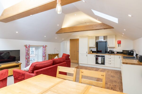 Open plan living and kitchen area in the luxury Grooms' Quarters self-catering apartment at Netherby Hall, Cumbria
