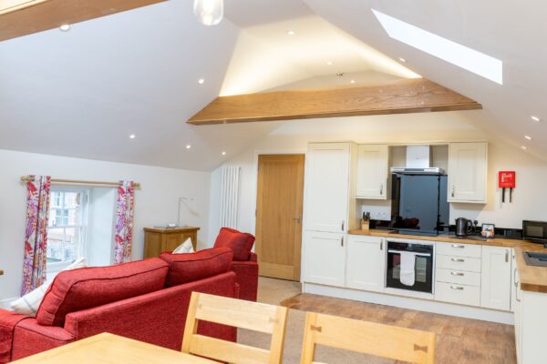 Modern open plan kitchen and living area in Grooms' Quarters luxury self-catering apartment at Netherby Hall, Cumbria
