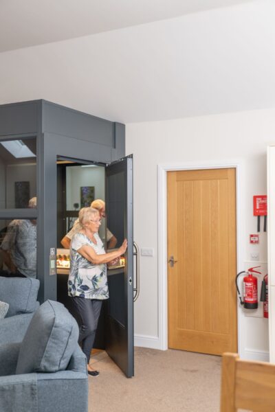 Woman entering a modern elevator inside the luxury Independent Apartment at Netherby Hall