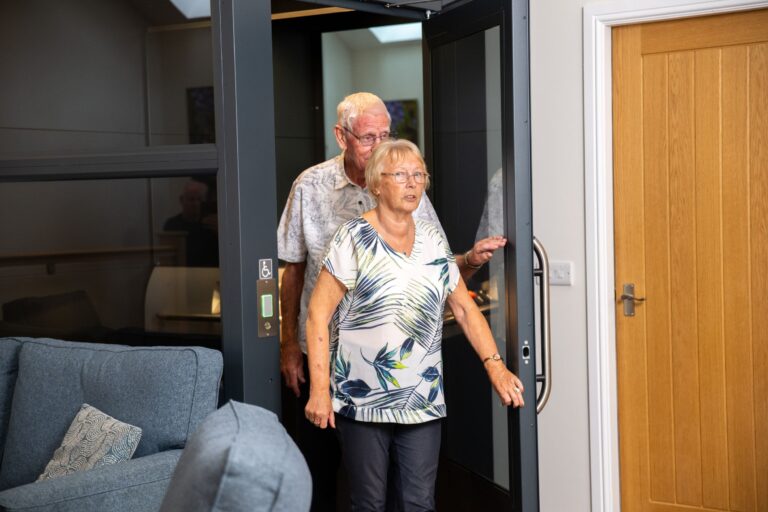 An elderly couple smiling while entering the Independent Apartment at Netherby Hall, luxury self-catering accommodation in Cumbria