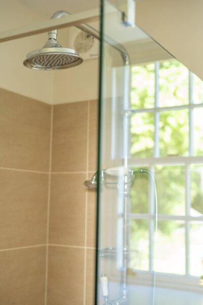 Modern shower head and glass enclosure in the luxury Salutation Apartment at Netherby Hall, Cumbria