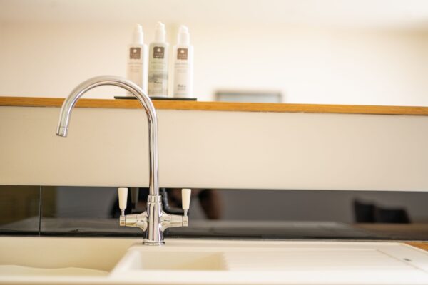 Modern chrome kitchen tap and sink in the luxury Salutation Apartment at Netherby Hall, Cumbria