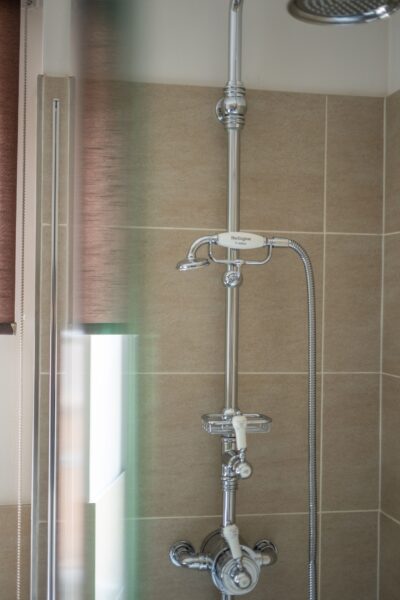 Chrome shower fixture and sliding rail in the luxury Salutation Apartment at Netherby Hall, Cumbria