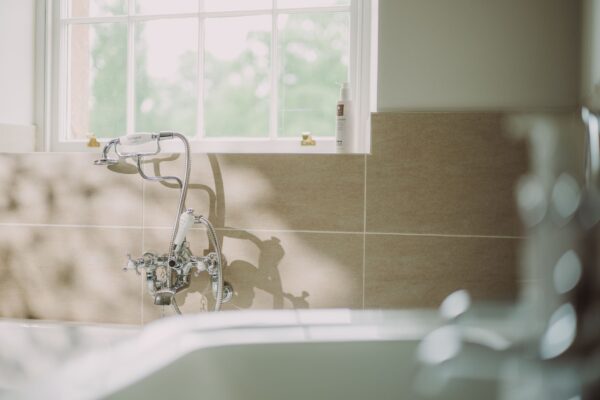 Chrome bathtub faucet and shower attachment in the luxury Sir Walter Scott Apartment at Netherby Hall, Cumbria
