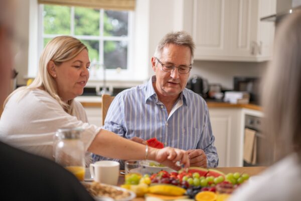 Couple enjoying a fresh fruit breakfast in the kitchen of the Sir Walter Scott Apartment at Netherby Hall, Cumbria
