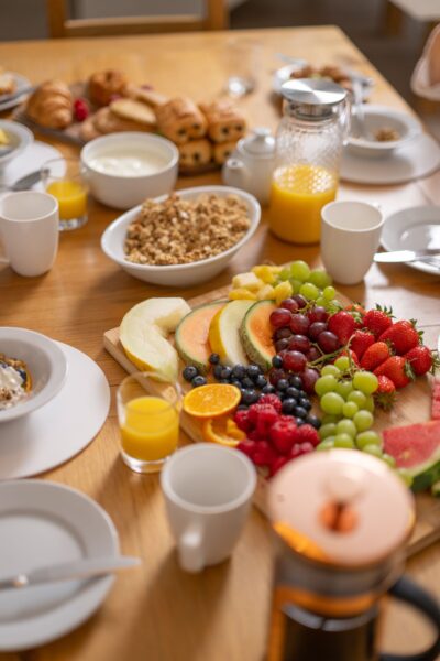 A delicious breakfast spread with fresh fruit, granola, pastries, and orange juice in the Sir Walter Scott Apartment at Netherby Hall