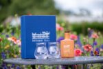 Netherby Hall gin gift set with a blue branded box and two glasses set against a lush garden background