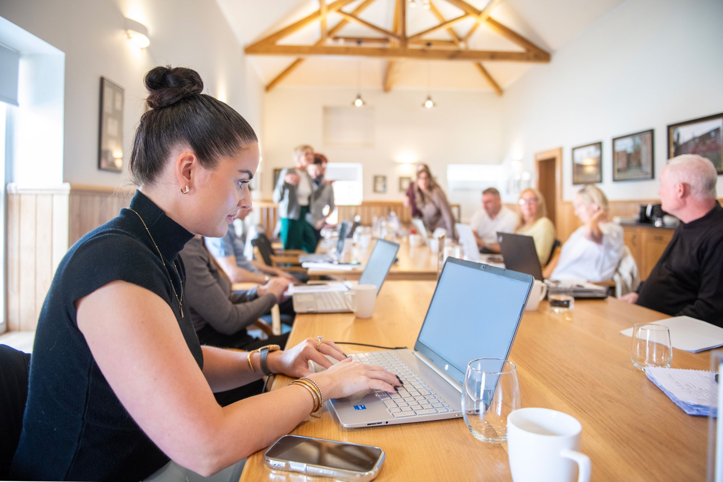 Attendees using laptops at a long table during a workshop in the function room at Netherby Hall